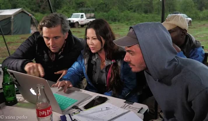 Xtina Parks reviewing footage on a laptop with the field team at camp
